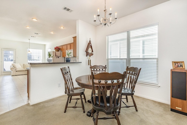 dining room featuring a chandelier and light carpet