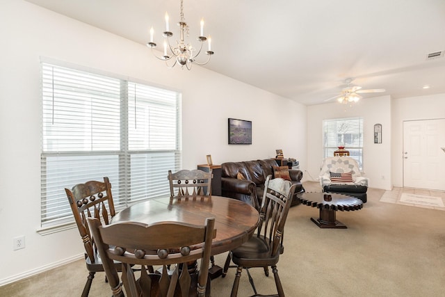 carpeted dining room featuring ceiling fan with notable chandelier