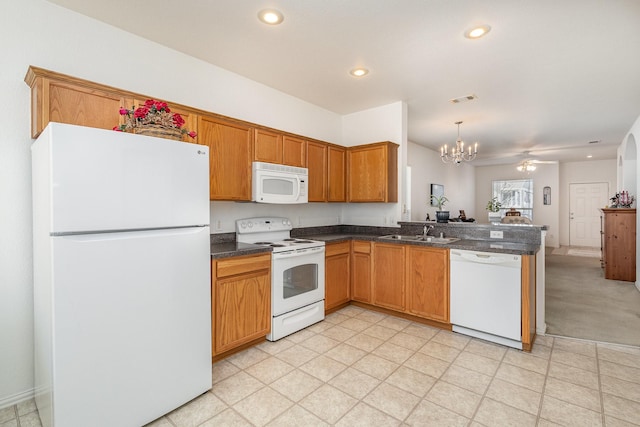 kitchen with white appliances, hanging light fixtures, sink, kitchen peninsula, and ceiling fan with notable chandelier