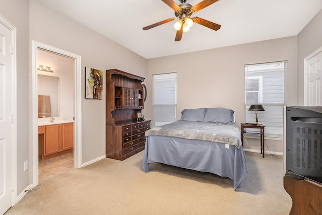 bedroom with ceiling fan, light colored carpet, connected bathroom, and sink