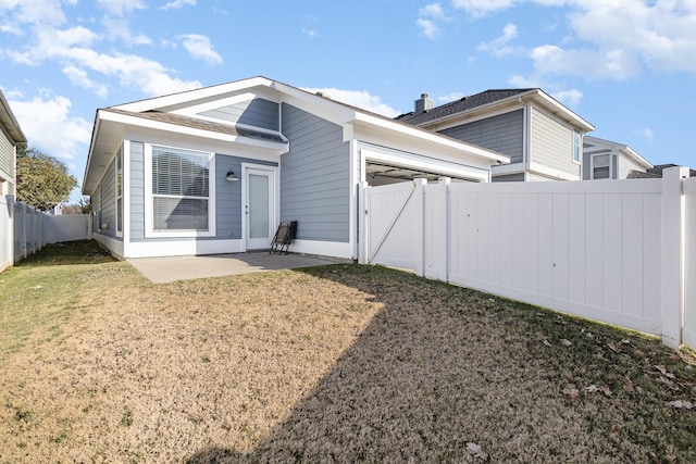 rear view of house with a patio area and a lawn