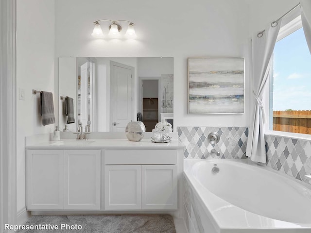 bathroom with a relaxing tiled tub and vanity