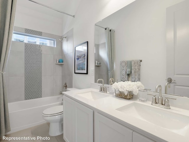 full bathroom with tile patterned flooring, vanity, tiled shower / bath combo, and toilet