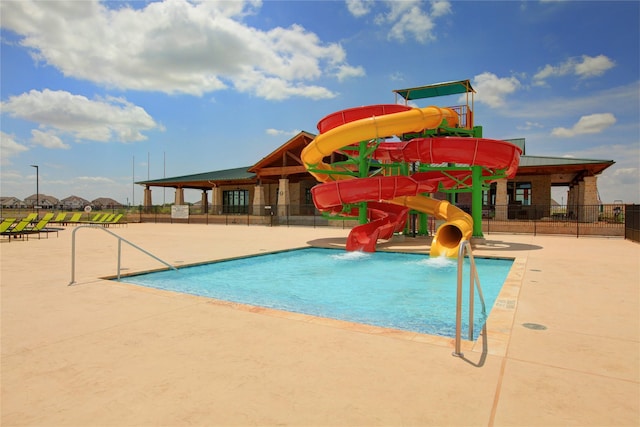 view of swimming pool featuring a water slide and a patio