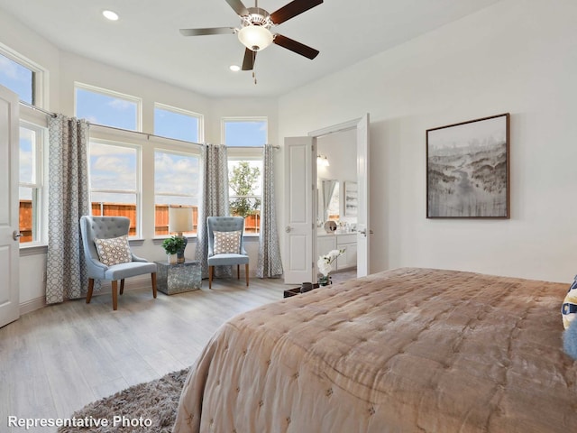 bedroom with ceiling fan, light hardwood / wood-style floors, and multiple windows