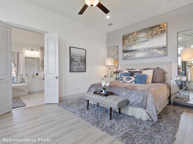 bedroom featuring hardwood / wood-style floors, ceiling fan, and connected bathroom