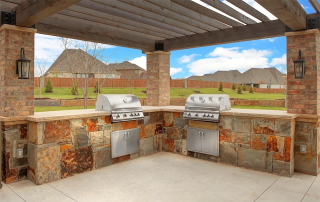 view of patio featuring a pergola, a grill, and exterior kitchen