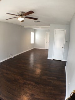 unfurnished room with dark wood-type flooring and ceiling fan