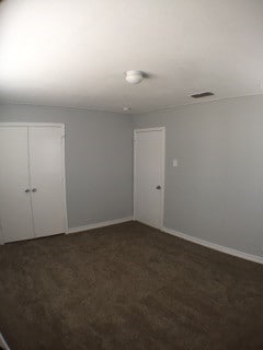 empty room featuring dark colored carpet