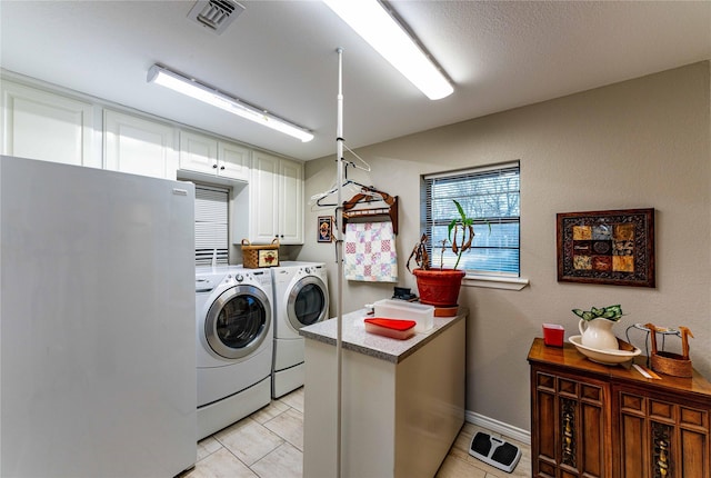 laundry area with separate washer and dryer and light tile patterned floors