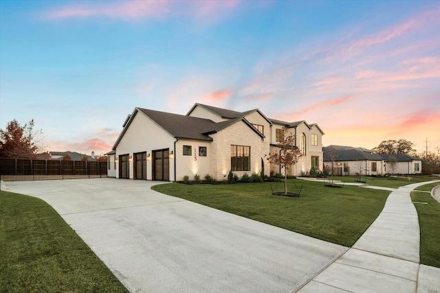 view of front of property featuring a garage and a lawn