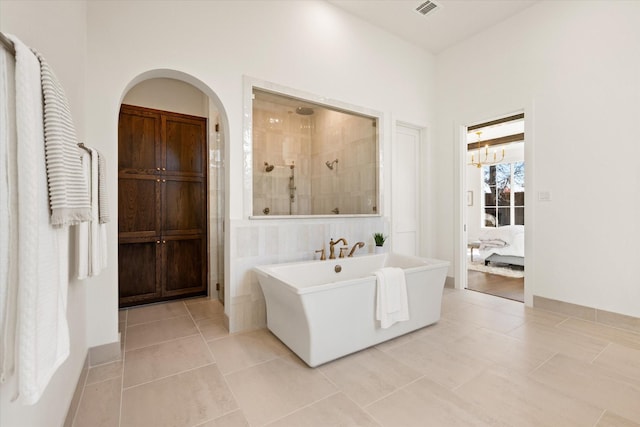 bathroom with tile patterned flooring, a notable chandelier, and shower with separate bathtub