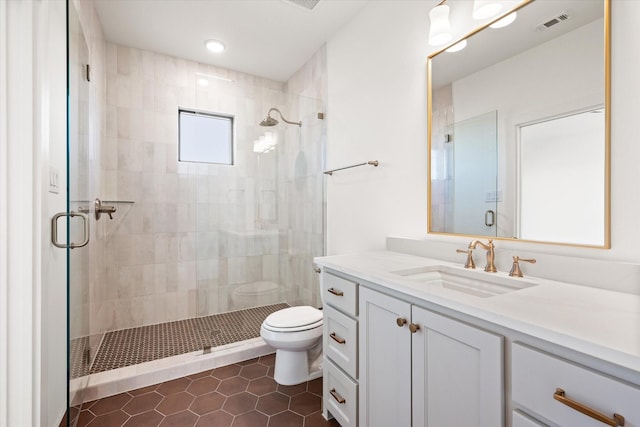 bathroom featuring tile patterned flooring, vanity, toilet, and a shower with door