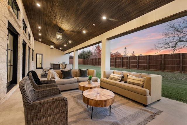 patio terrace at dusk with an outdoor hangout area and a lawn