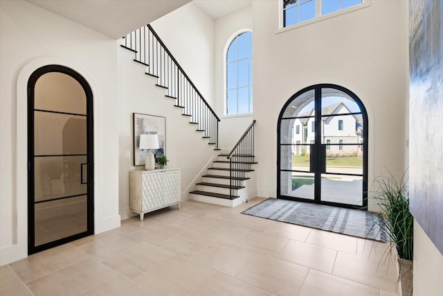 tiled foyer with a wealth of natural light and a towering ceiling