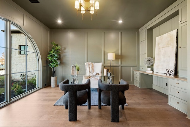 dining room with an inviting chandelier, light hardwood / wood-style flooring, and a wealth of natural light