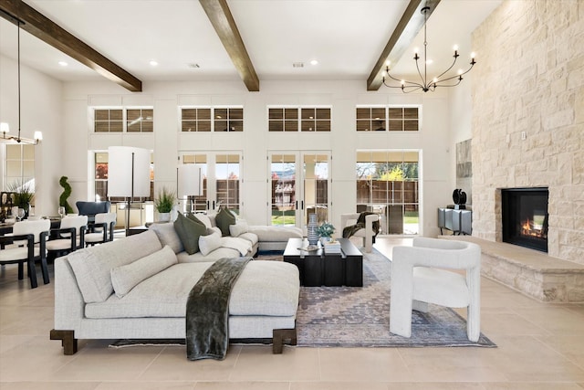 tiled living room with beam ceiling, a towering ceiling, a fireplace, and french doors