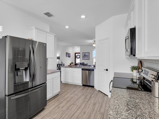 kitchen featuring light hardwood / wood-style flooring, stainless steel refrigerator with ice dispenser, light stone counters, white cabinets, and decorative backsplash