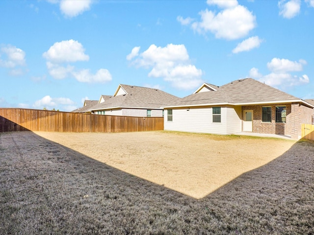 rear view of property with a patio area, a fenced backyard, and brick siding