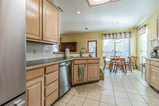 kitchen with sink, hanging light fixtures, stainless steel appliances, kitchen peninsula, and decorative backsplash