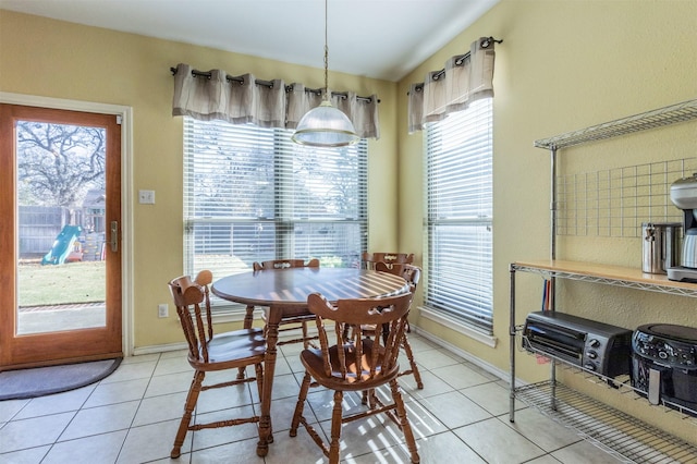 tiled dining room with lofted ceiling