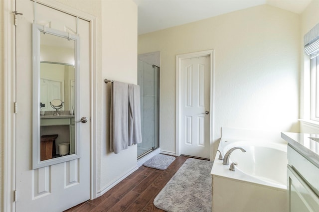 bathroom featuring hardwood / wood-style flooring, vanity, independent shower and bath, and vaulted ceiling