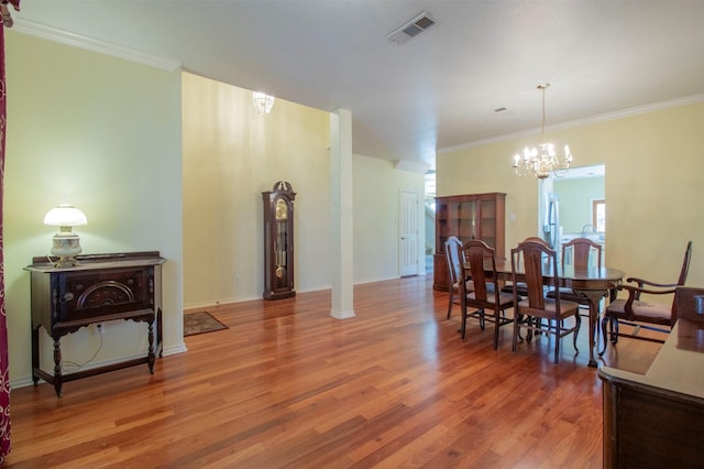 dining room featuring hardwood / wood-style floors, crown molding, and a chandelier