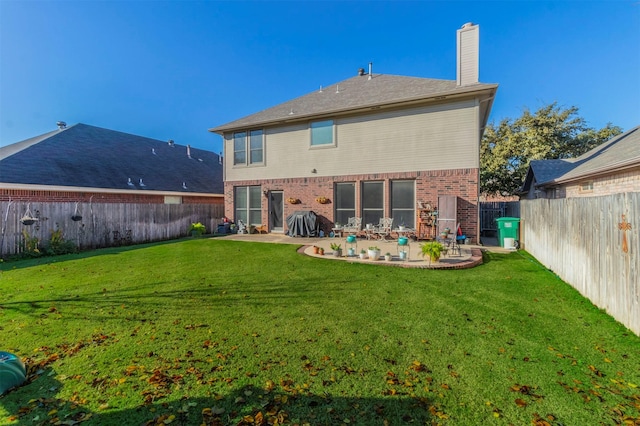 rear view of property featuring a yard and a patio area