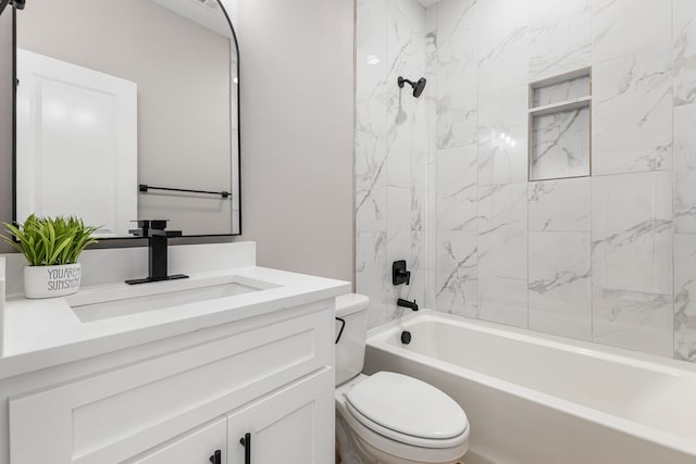 full bathroom featuring tiled shower / bath combo, toilet, and vanity