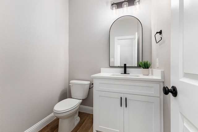 bathroom with wood-type flooring, vanity, and toilet