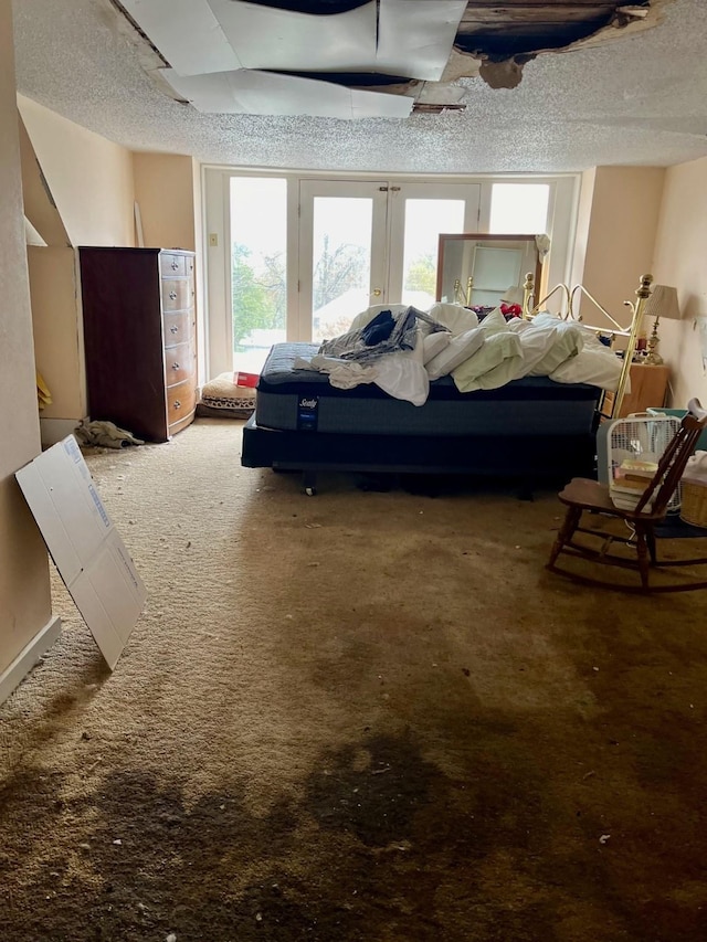 bedroom featuring french doors, carpet floors, and a textured ceiling