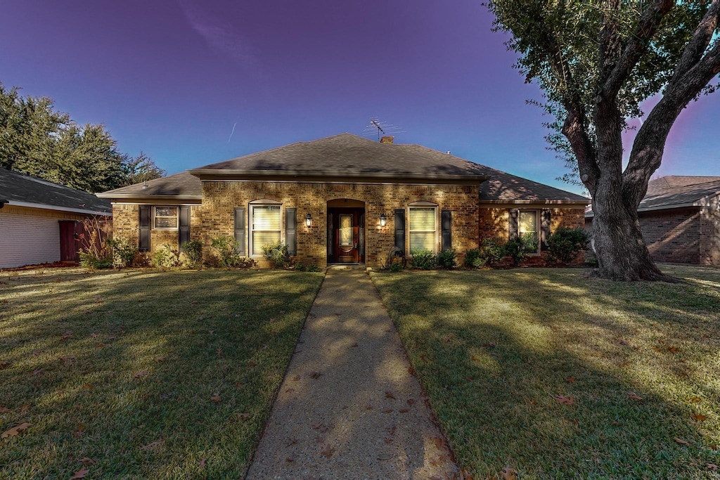 ranch-style home featuring a yard