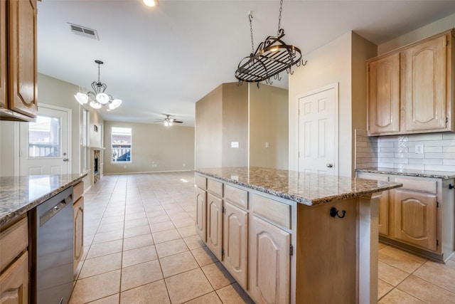 kitchen featuring dishwasher, light tile patterned flooring, ceiling fan with notable chandelier, hanging light fixtures, and a kitchen island