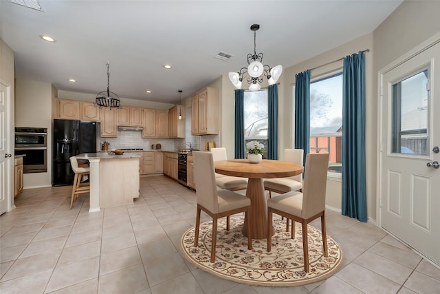 dining area featuring light tile patterned floors and an inviting chandelier