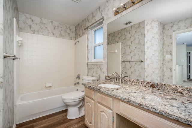 full bathroom featuring vanity, toilet, wood-type flooring, and tiled shower / bath