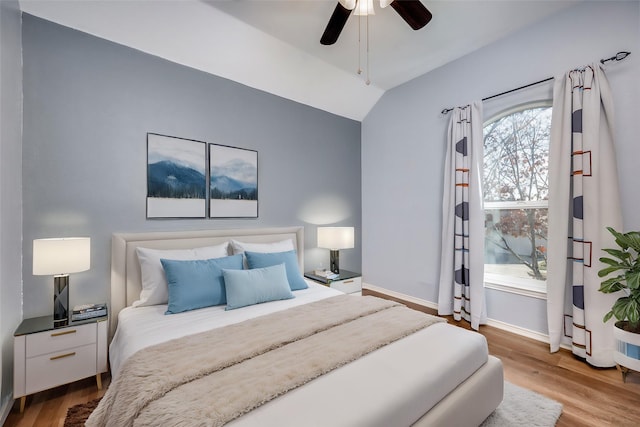 bedroom with ceiling fan, wood-type flooring, and vaulted ceiling