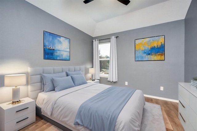 bedroom featuring ceiling fan, vaulted ceiling, and light wood-type flooring