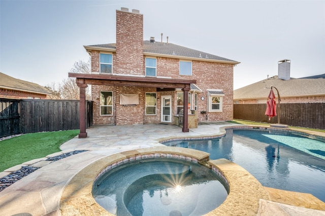 rear view of house featuring a patio and a pool with hot tub