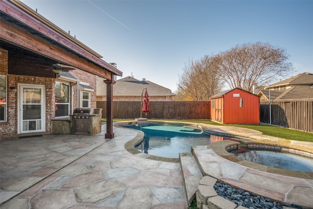 view of swimming pool featuring a patio area, a shed, and an in ground hot tub