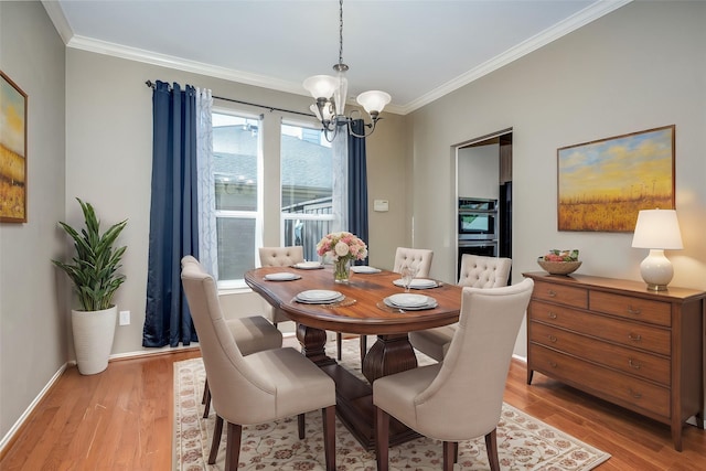 dining area featuring a healthy amount of sunlight, light hardwood / wood-style floors, ornamental molding, and a notable chandelier