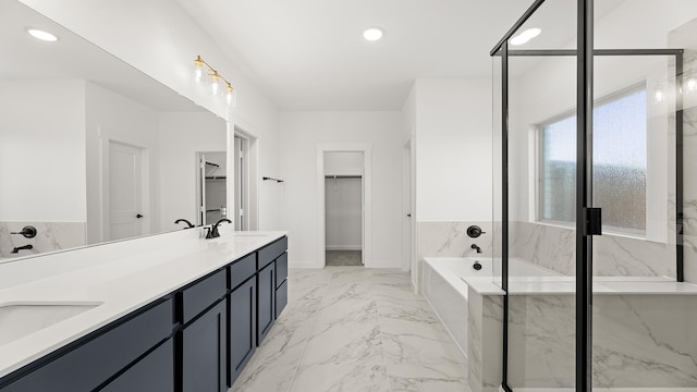 bathroom featuring a sink, a marble finish shower, a garden tub, a spacious closet, and marble finish floor