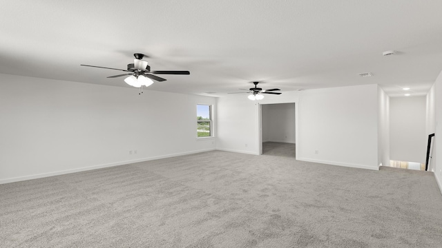carpeted empty room featuring visible vents, ceiling fan, and baseboards