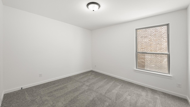 unfurnished room featuring carpet flooring and baseboards