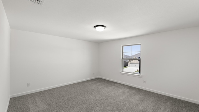 spare room featuring carpet flooring and baseboards