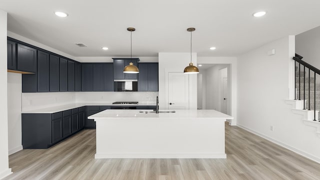 kitchen featuring visible vents, light wood-type flooring, light countertops, and a sink