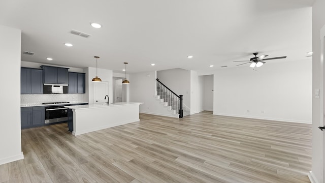 kitchen with open floor plan, light countertops, recessed lighting, and a sink