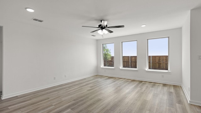empty room with visible vents, ceiling fan, light wood-style floors, and baseboards