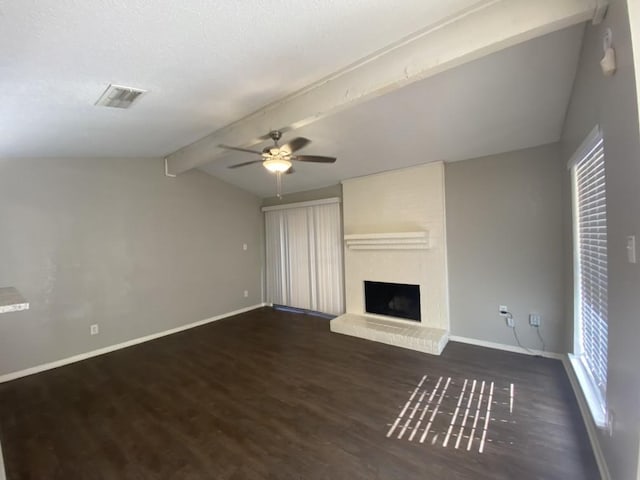 unfurnished living room with vaulted ceiling with beams, ceiling fan, a large fireplace, and dark hardwood / wood-style floors