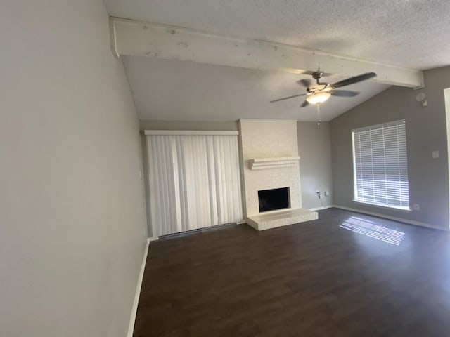 unfurnished living room with lofted ceiling with beams, a brick fireplace, dark hardwood / wood-style floors, ceiling fan, and a textured ceiling