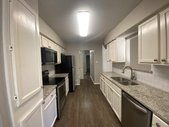 kitchen with appliances with stainless steel finishes, light stone counters, sink, white cabinets, and dark hardwood / wood-style floors